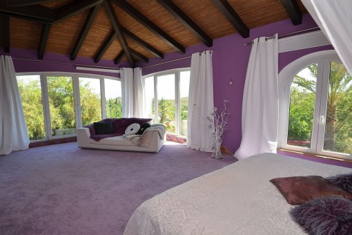 Das Schlafzimmer bietet einen Teppichboden mit Holzdeckenbalken